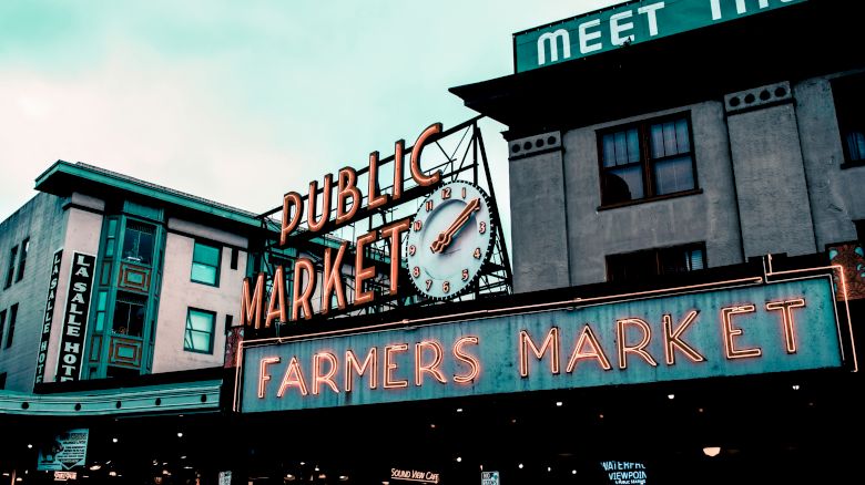 The image shows the iconic signage of a "Public Market" and "Farmers Market" with a clock, likely indicating a well-known market location.